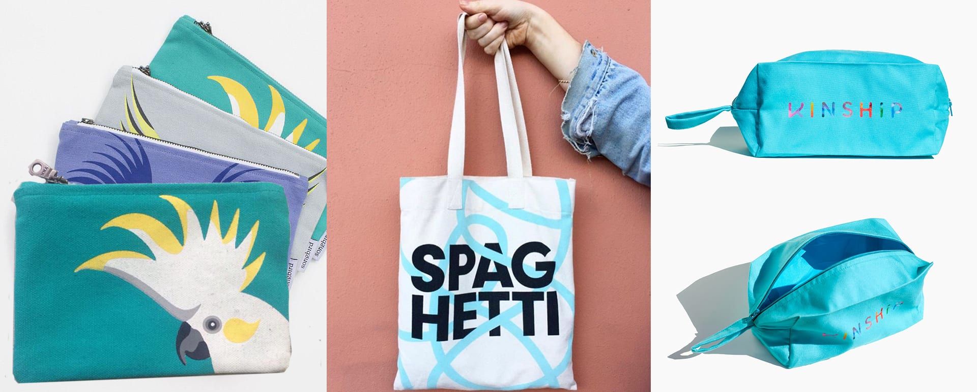 Two Work+Shelter artisans holding custom-branded canvas tote bags for a corporate client